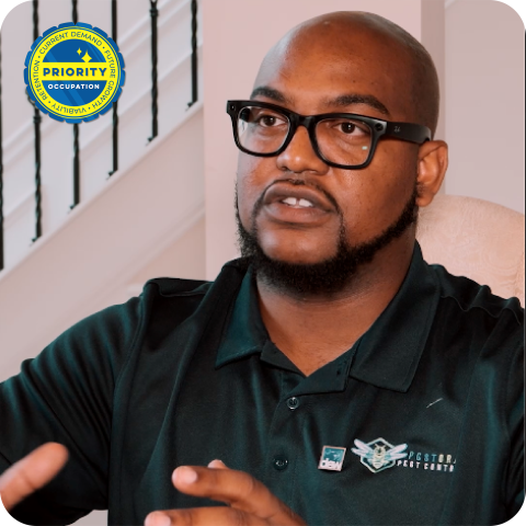 Man with pest control logo on shirt sitting at table 